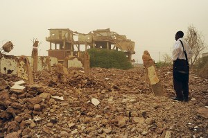 Fourteen years after the fact, a Sudanese man gazes at the wreckage of the Al-Shifa pharmaceutical plant.